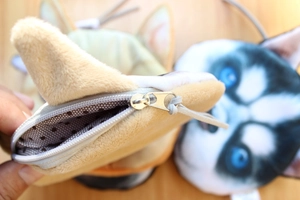 Close-up of plush dog coin purse showing soft material and polka dot inner lining detail
