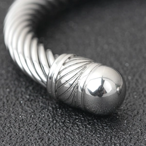 Macro shot of silver cable wire bracelet ends with detailed metal texture and polished finish