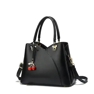 Detail of elegant handbags featuring cat-ear metal handles and cherry charm in various colors