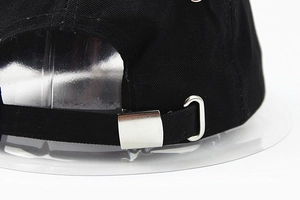 Détail de la sangle arrière de casquette de baseball noire avec boucle métallique argentée