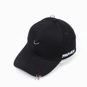 Détail de trois anneaux métalliques sur la visière et broderie blanche sur casquette noire