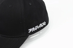 Détail de la broderie katakana japonaise blanche sur le côté d'une casquette noire