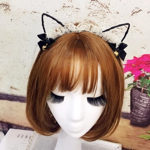 Detail of cute cat ear headband with white lace trim and black bows with golden bells