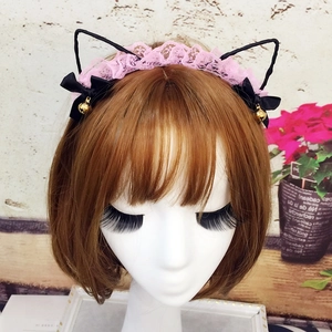 Pink lace cat ear headband with black bows and golden bells on a display model