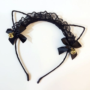 Close-up of black lace cat ears headband with ribbon bows and golden metal bells