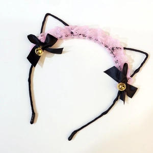 Detail of lace cat ear headband with black ribbons, pink lace, and golden bells
