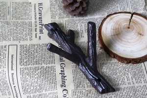 Macro detail of rustic cast iron wall hook in a vintage brown tree branch design