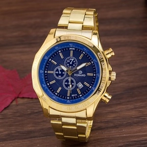 Detail of gold metal watch with blue dial and three sub-dials on autumn background