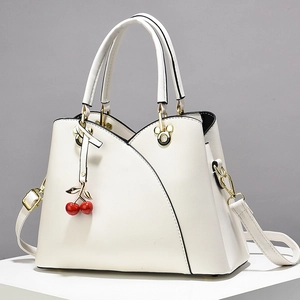 White faux leather tote bag with cherry charm and Mickey-shaped metal hardware details