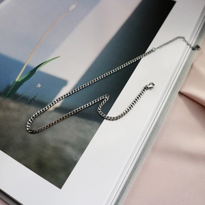 Detailed macro view of 925 sterling silver curb chain necklace with lobster clasp closure