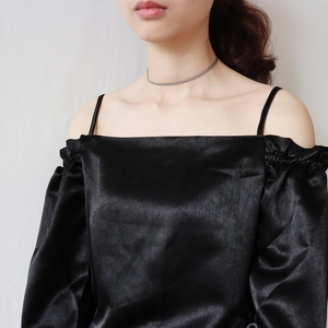 Close-up of 925 sterling silver chain necklace with black off-shoulder satin dress