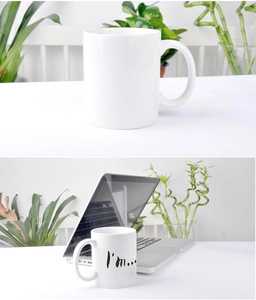 Detail of white ceramic mug featuring minimalist I'm... text on a clean desktop setting