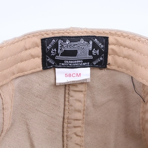 Détail intérieur d'une casquette plate en coton kaki avec étiquette de taille et marque