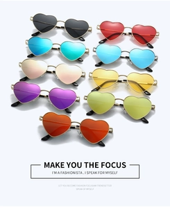 Flat lay of heart shaped metal sunglasses in nine vibrant colors with shadow details