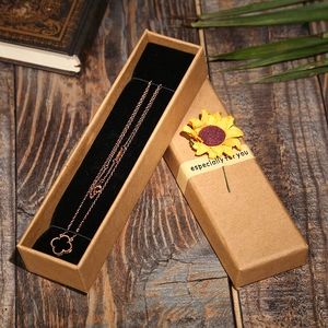 Brown kraft jewelry gift box with sunflower ribbon and clover necklace on black velvet liner