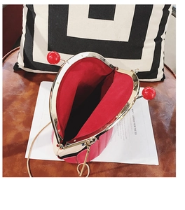 Detail of pink and red cake-shaped crossbody bag showing open compartment and metal clasp