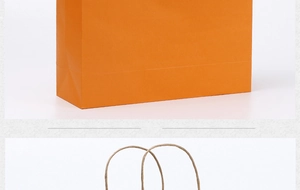 Detail view of orange kraft paper bag with sturdy paper twist handles and reinforced base