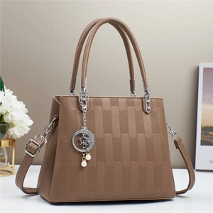 Detailed view of brown checkered textured handbag with pearl star and moon charm
