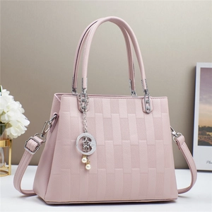 Pink textured handbag detail featuring woven pattern, silver star moon pendant and pearls