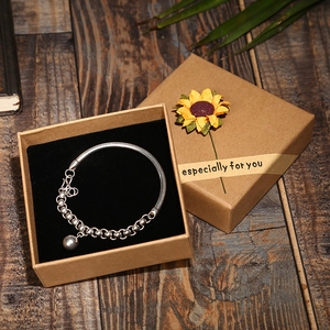 Silver bead bracelet with spherical pendant in a kraft gift box with sunflower