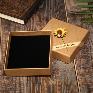 Macro shot of open kraft paper jewelry box with sunflower and especially for you ribbon