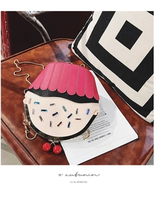 Detailed view of cupcake crossbody bag with cherry charm and gemstone accents