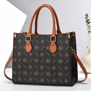 Detail view of large leather tote bag with vintage monogram and gold metal hardware