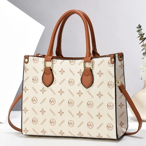 Chic cream leather tote bag with monogram print and brown top handles on geometric background