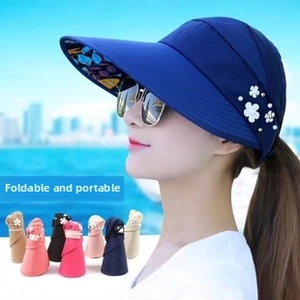 Detail of navy blue sun visor with decorative flowers, pearls and foldable design