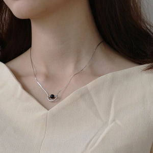 Detail of 925 sterling silver snake chain necklace featuring a round black onyx pendant