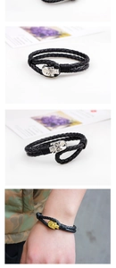 Detailed view of woven leather bracelet featuring a metallic skull charm clasp