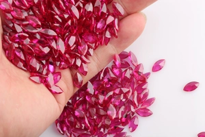 Detailed close-up of marquise-cut deep red synthetic rubies held in hand for jewelry making