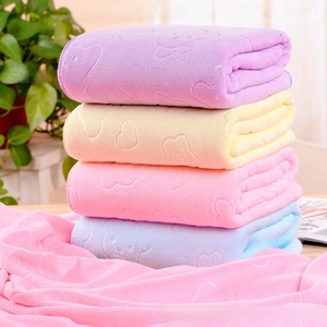 Detail of embossed bear and heart patterns on soft microfiber towels in pastel colors