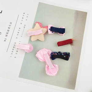 Detail view of colorful girls' hair clips featuring mink fur pom-poms and floral bows