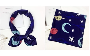 Detail of silk scarf with starry sky print featuring planets and stars on navy blue satin