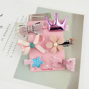Detail of 6-piece children hair clips featuring crowns and bows on pink display card