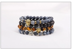 Detailed stack of tiger eye and lava stone bracelets with leopard head metal charms