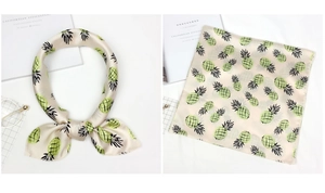 Detailed view of square silk scarf with green pineapple pattern and elegant satin finish