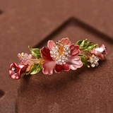 Détail macro de la pince à cheveux vintage en émail rose et strass scintillants