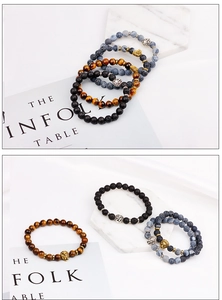 Close-up of lava rock, tiger eye and agate beaded bracelets with golden lion head charms