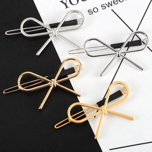 Close-up of four metallic bow hair clips in gold and silver with anti-slip sleeves