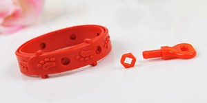 Vue détaillée d'un collier anti-puces rouge avec motifs de pattes et boucle réglable