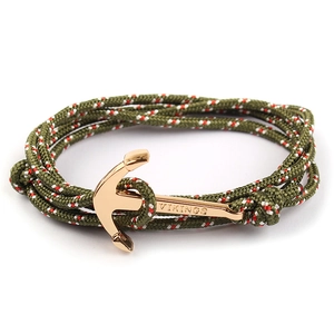Detail of nautical green woven rope bracelet with engraved golden anchor clasp