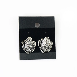 Macro view of butterfly earrings in antique silver finish with dark gemstones