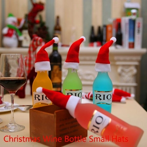 Mini plush Christmas hats for wine bottles and cutlery set on a festive table