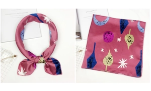 Close-up of vibrant floral silk scarf with abstract pink, blue, and yellow leaf patterns