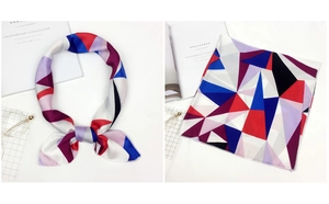 Detail of square silk scarf with geometric color blocks and glossy satin finish