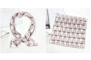 Detail of white square silk scarf featuring pink cartoon rabbit patterns and smooth satin finish