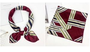 Detail of silk satin square scarf with geometric stripe pattern in burgundy and navy