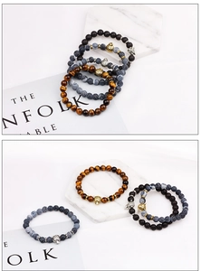 Detailed view of beaded tiger eye bracelets with engraved leopard heads on marble tray